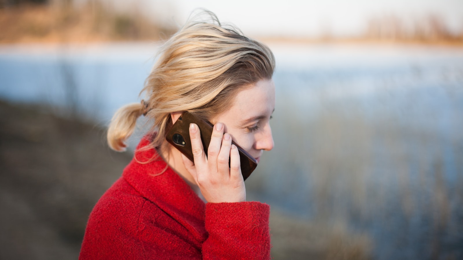 A woman mid-conversation with a phone held to her ear