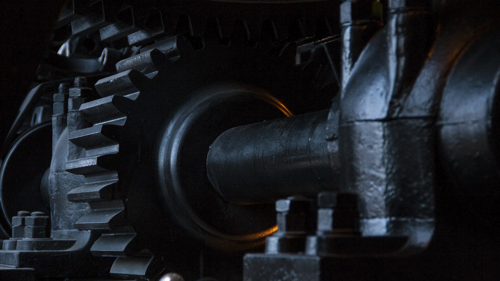 Close-up macro shot of old, dark metal gears and cogs with their teeth interlocked