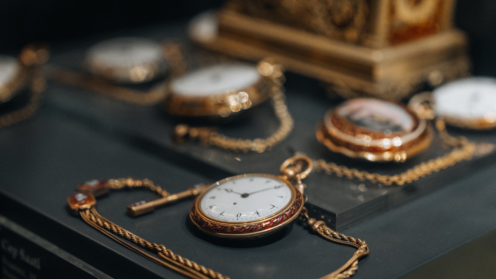 A collection of antique pocket watches displayed together, their worn cases suggesting decades of past use.